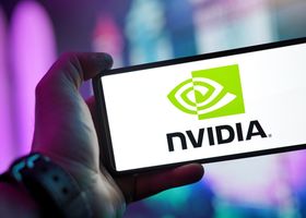 Close-up of a hand holding a smartphone showing the NVIDIA logo on screen with a blurred background.